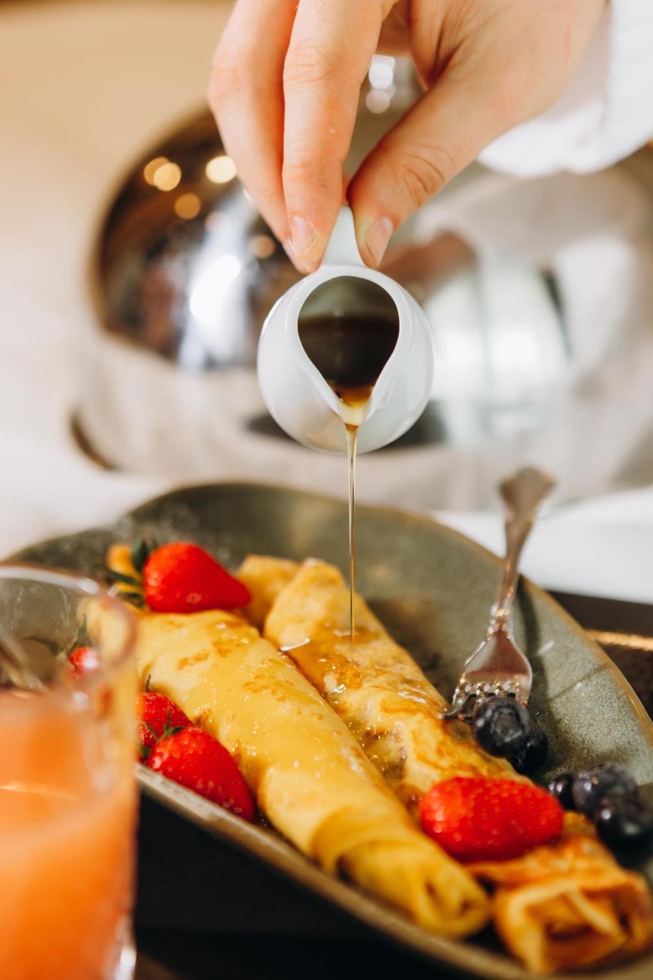 Hotel Platinia Cluj Napoca Bagian luar foto Maple syrup being poured onto crêpes