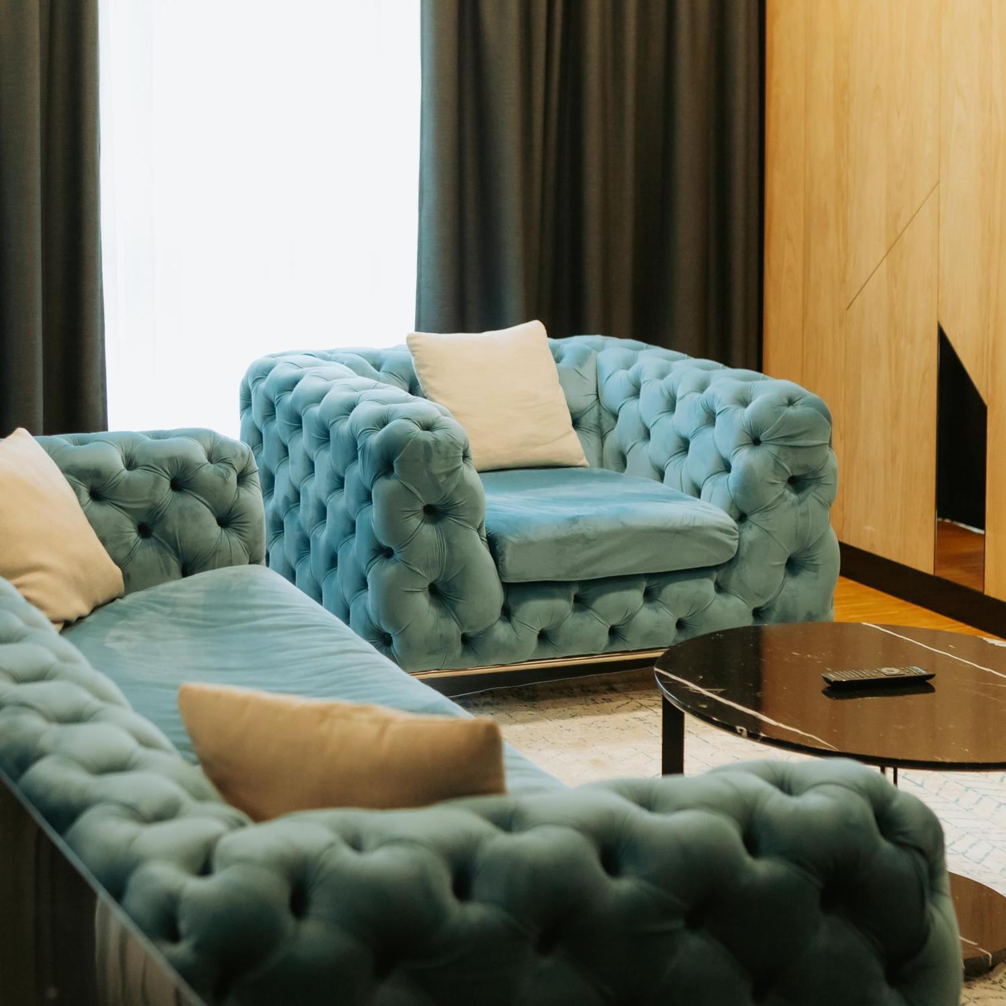 Hotel Platinia Cluj Napoca Bagian luar foto A blue velvet Chesterfield sofa